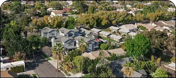An aerial view of houses nestled in a lush, green hillside for a trip from LAX to Pasadena.