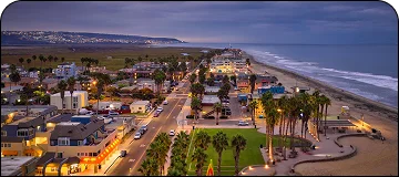 Aerial view along the San Diego to Tijuana route showing a small coastal town overlooking the ocean.